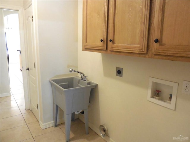 washroom with hookup for an electric dryer, cabinets, light tile patterned floors, and washer hookup