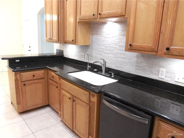 kitchen featuring dishwasher, backsplash, dark stone counters, and sink