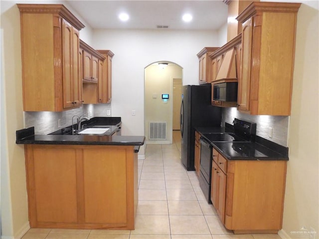 3519 Aspen Dr, Edinburg, TX 78542 - kitchen with black appliances, decorative backsplash, a peninsula, arched walkways, and recessed lighting