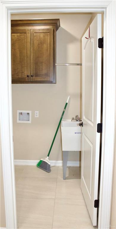 laundry area with hookup for a washing machine and light tile patterned flooring