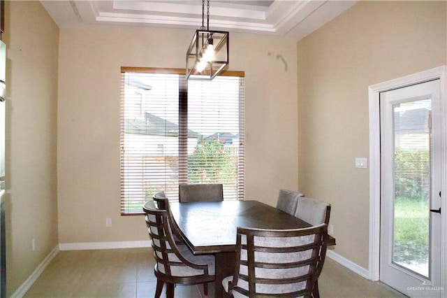 tiled dining area with a healthy amount of sunlight and a raised ceiling