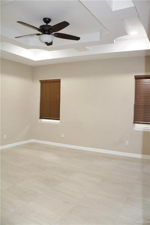 spare room featuring a tray ceiling and ceiling fan