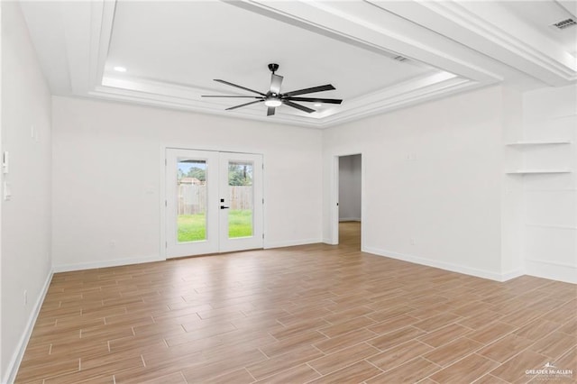 spare room with a raised ceiling, ceiling fan, and french doors