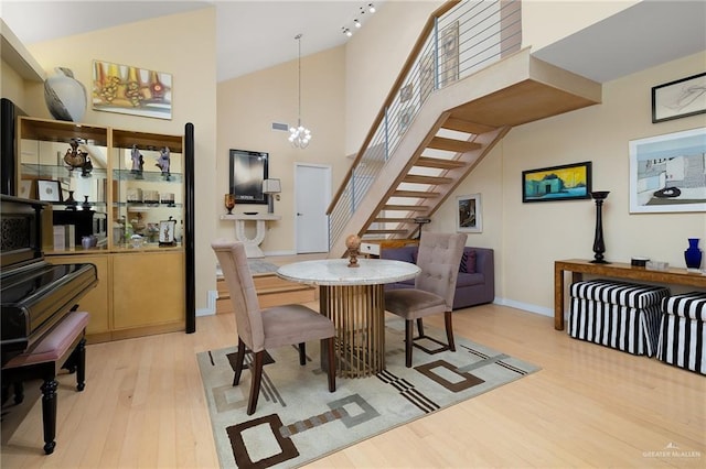1113 Xanthisma Ave, Mcallen, TX 78504 - dining area featuring an inviting chandelier, stairway, baseboards, light wood-type flooring, and a high ceiling