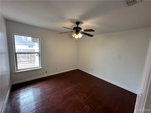 spare room featuring visible vents, baseboards, dark wood-style floors, and a ceiling fan