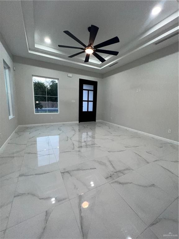 spare room with a tray ceiling, ceiling fan, and french doors