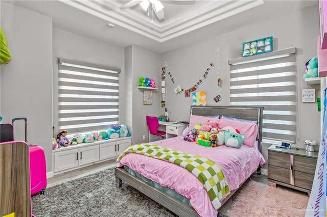 bedroom featuring ceiling fan and a raised ceiling