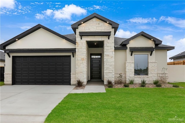 3119 N Elm Ave, Edinburg, TX 78541 - view of front facade featuring stone siding, a garage, concrete driveway, a front lawn, and stucco siding