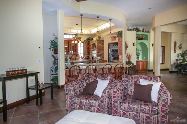 tiled living room with a notable chandelier