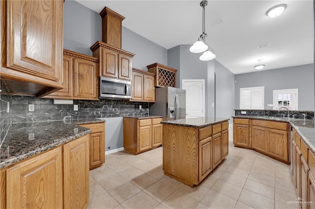 3902 Green Jay Dr, Mission, TX 78572 - kitchen with stainless steel appliances, backsplash, dark stone counters, light tile patterned floors, and hanging light fixtures