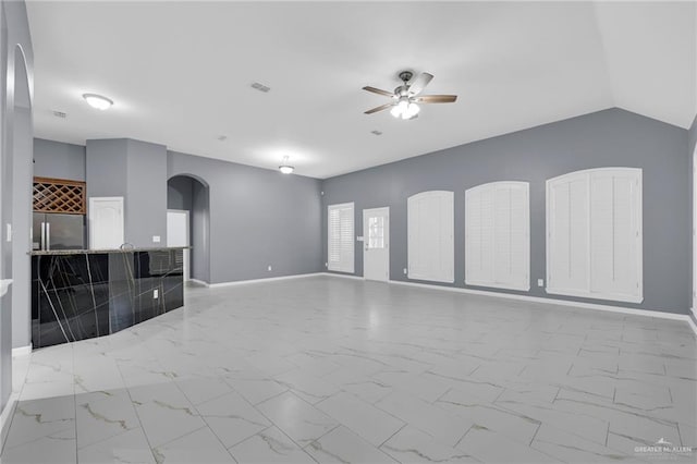 3902 Green Jay Dr, Mission, TX 78572 - unfurnished living room with arched walkways, a ceiling fan, marble finish flooring, and baseboards