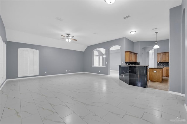 3902 Green Jay Dr, Mission, TX 78572 - unfurnished living room with arched walkways, ceiling fan, light marble finish floors, and baseboards