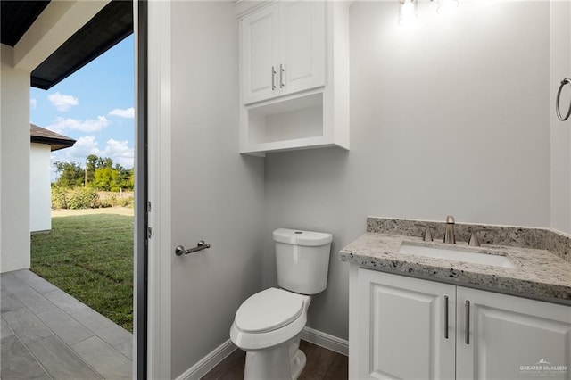 bathroom with wood-type flooring, vanity, and toilet