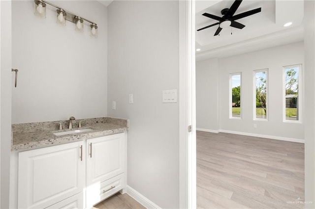 bathroom with hardwood / wood-style flooring, vanity, and ceiling fan