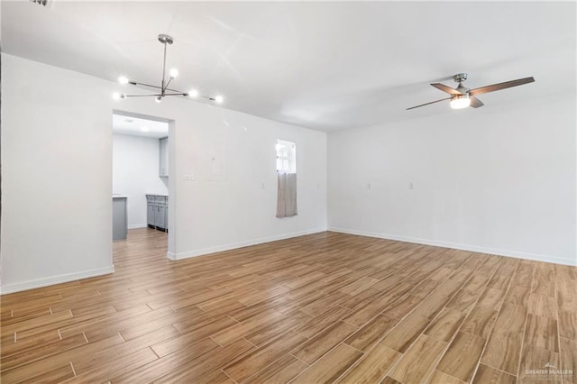 403 N 1st St, Donna, TX 78537 - unfurnished room featuring light wood-style flooring, a chandelier, ceiling fan, and baseboards