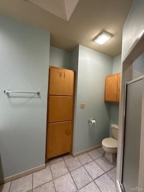 bathroom featuring a shower with door, tile patterned flooring, and toilet