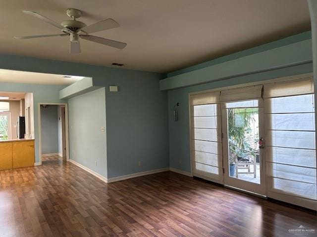 spare room featuring ceiling fan, plenty of natural light, and dark hardwood / wood-style floors