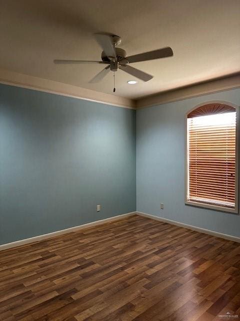 spare room featuring dark wood-type flooring and ceiling fan