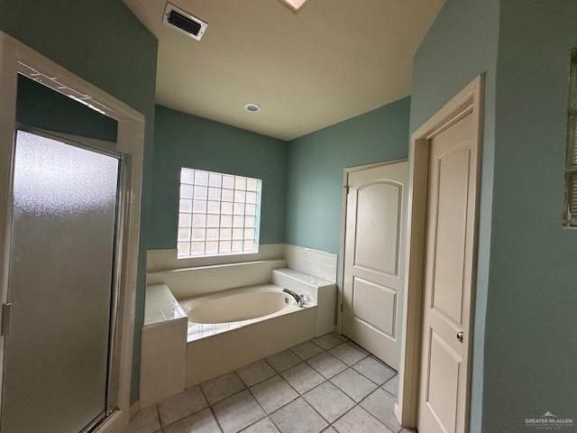 bathroom with tile patterned floors and plus walk in shower