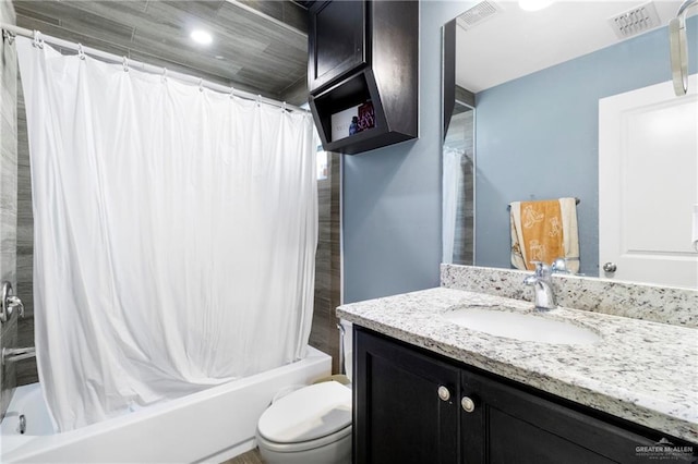 full bathroom with vanity, shower / tub combo, and toilet