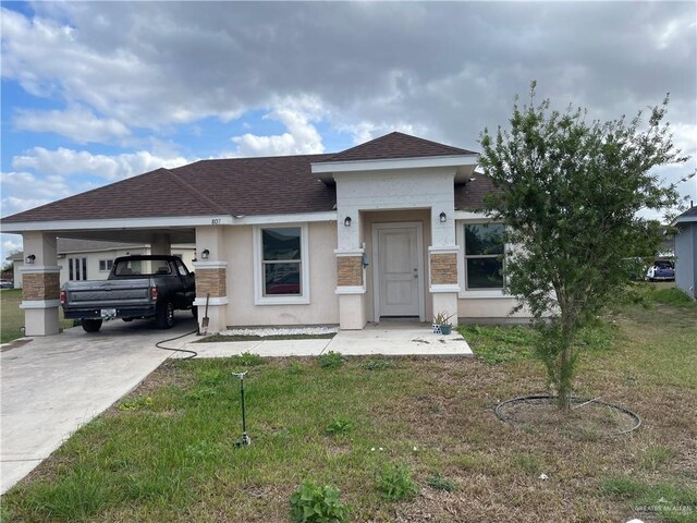 view of front of house with a front yard and a carport