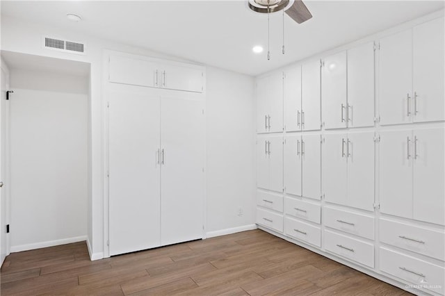 spacious closet with light hardwood / wood-style floors and ceiling fan