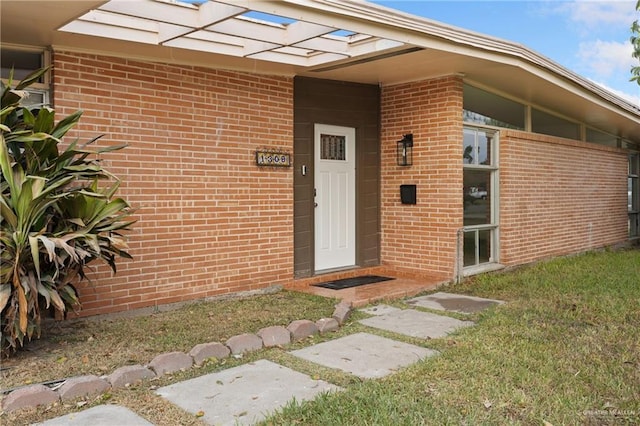 entrance to property featuring a lawn