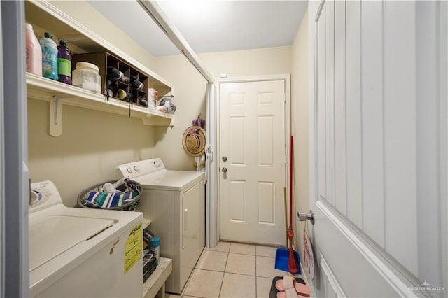 clothes washing area featuring washing machine and dryer and light tile patterned flooring