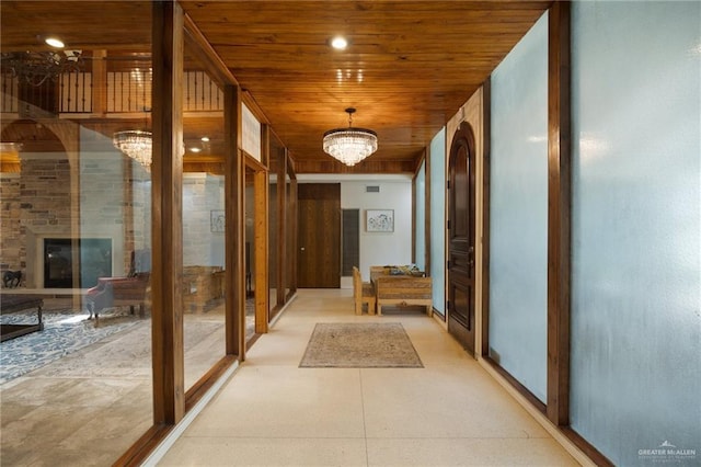 hall featuring wood ceiling and a chandelier