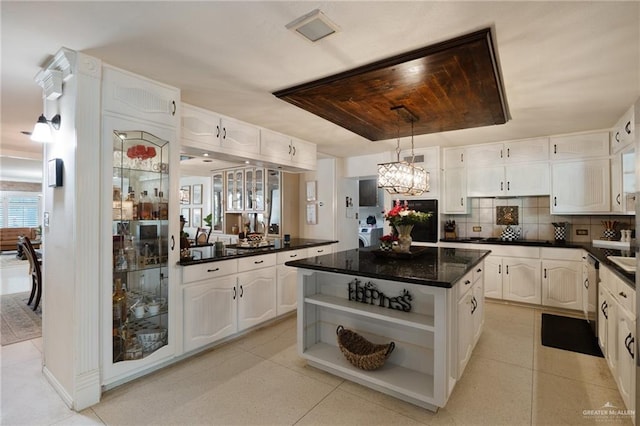 kitchen featuring decorative light fixtures, light tile patterned floors, a kitchen island, decorative backsplash, and white cabinets