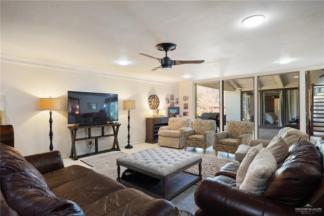 carpeted living room with crown molding and ceiling fan