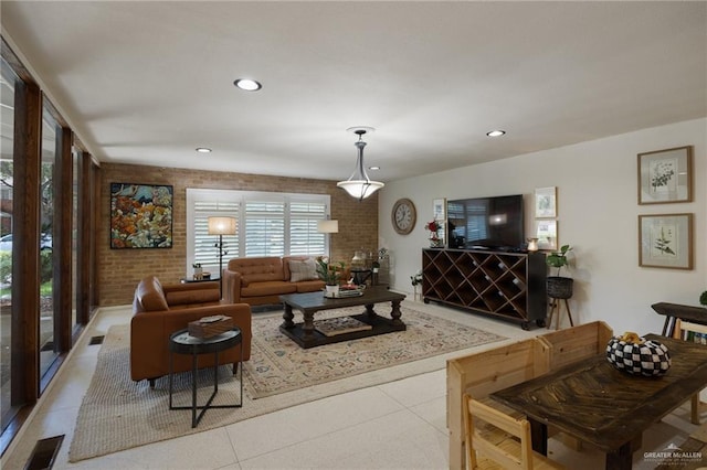 living room featuring light tile patterned floors and brick wall