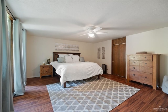 bedroom featuring dark wood-type flooring, ceiling fan, a closet, and a textured ceiling