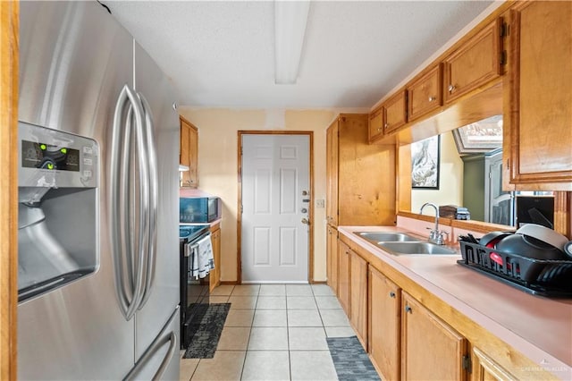 kitchen with sink, stainless steel appliances, and light tile patterned flooring