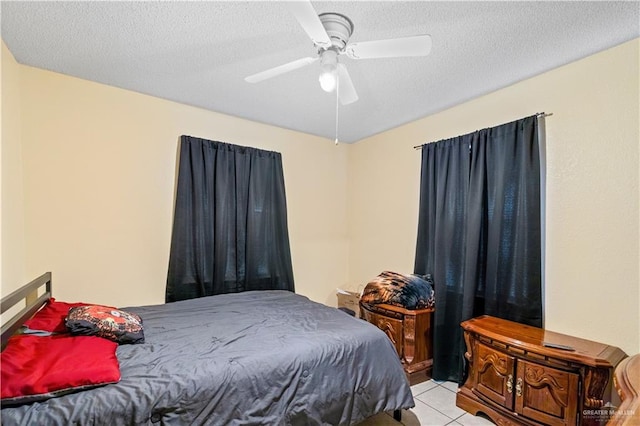 tiled bedroom featuring ceiling fan and a textured ceiling