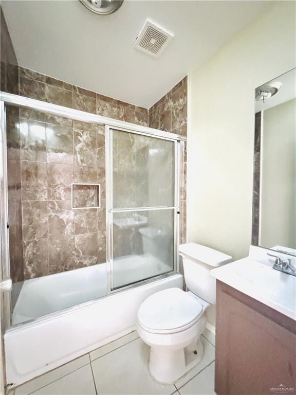 1411 Oak St, Weslaco, TX 78596 - bathroom featuring tile patterned floors, toilet, visible vents, vanity, and enclosed tub / shower combo