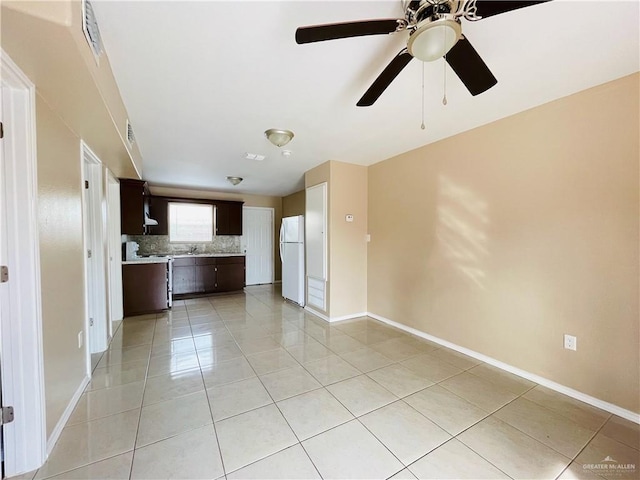 1411 Oak St, Weslaco, TX 78596 - unfurnished living room featuring ceiling fan, baseboards, and light tile patterned floors