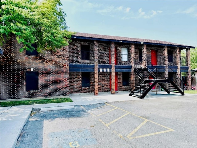 1411 Oak St, Weslaco, TX 78596 - view of property with stairs and uncovered parking