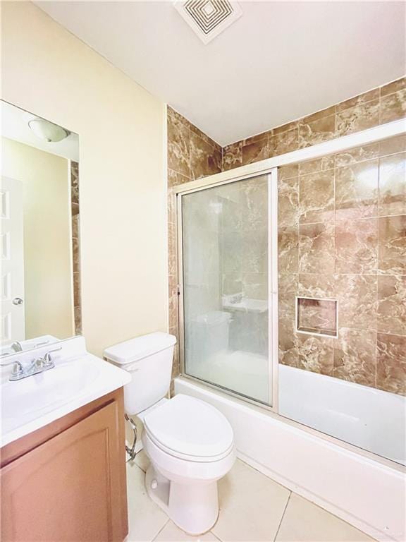 1411 Oak St, Weslaco, TX 78596 - full bath with tile patterned flooring, combined bath / shower with glass door, visible vents, toilet, and vanity
