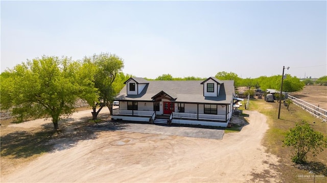 view of front facade featuring a porch and dirt driveway