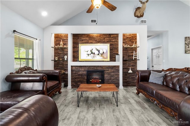 living room featuring visible vents, a fireplace, ceiling fan, and wood finished floors