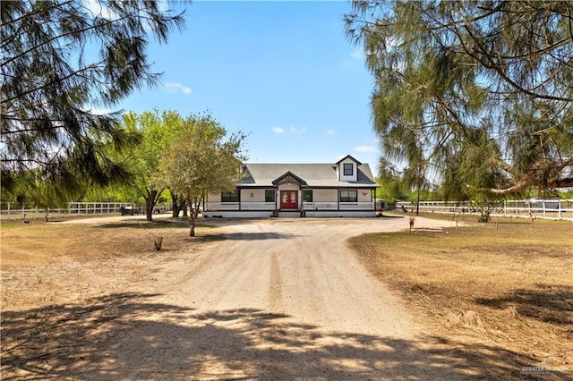 view of front of property with dirt driveway and fence