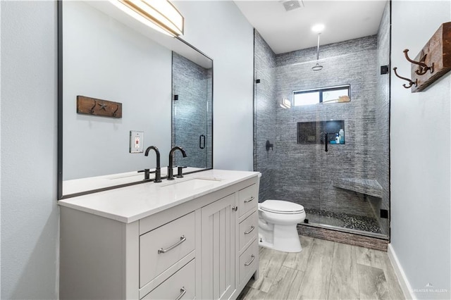 full bath featuring visible vents, toilet, a stall shower, wood finished floors, and vanity