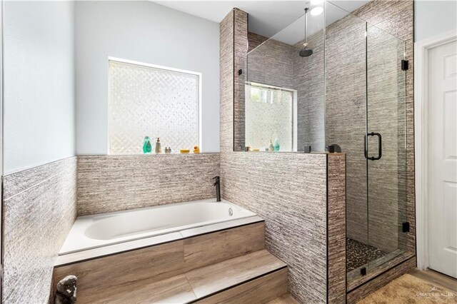 full bath featuring a garden tub and a shower stall