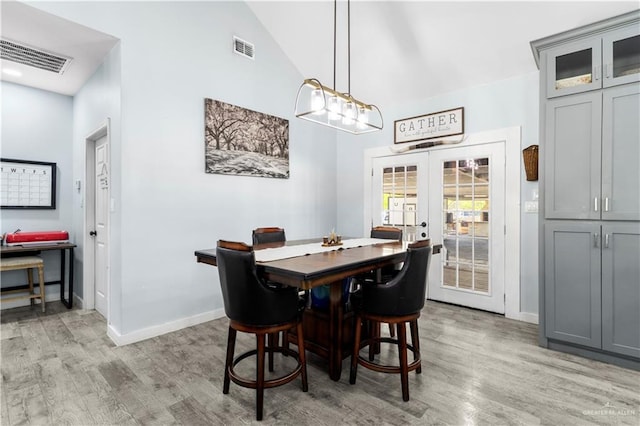 dining space featuring light wood finished floors, visible vents, and french doors