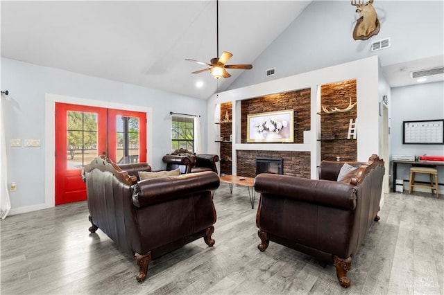 living room with ceiling fan, visible vents, and wood finished floors