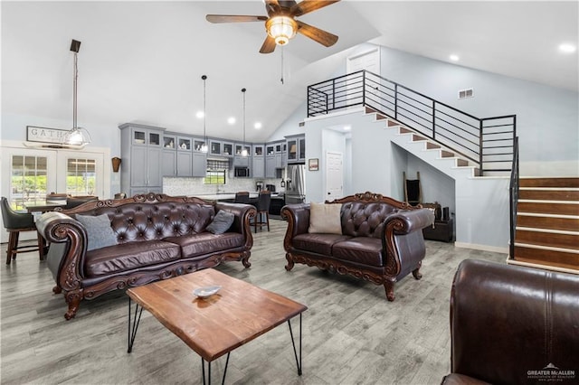 living area featuring stairway, light wood-style flooring, visible vents, and ceiling fan