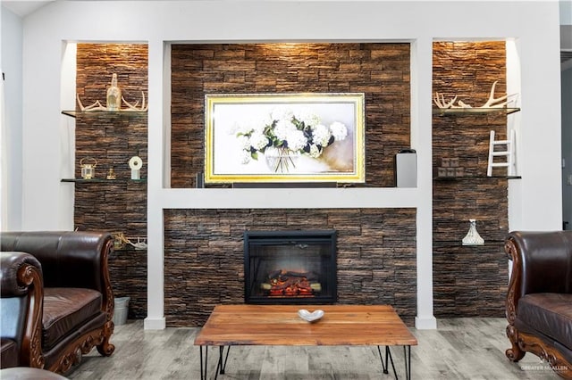 living room with lofted ceiling, wood finished floors, and a lit fireplace