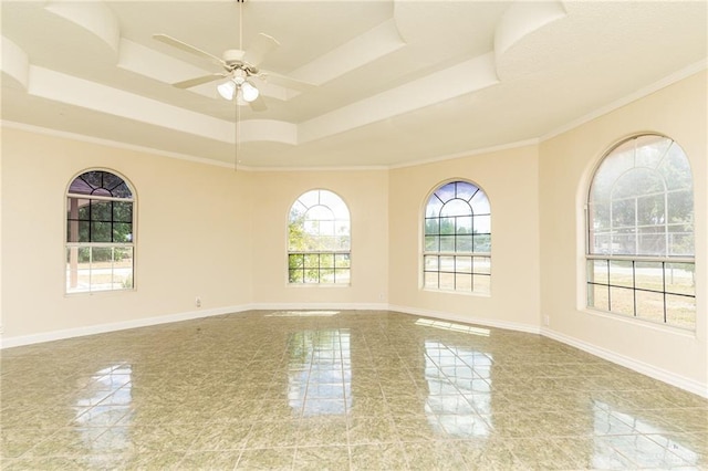 spare room featuring ceiling fan, ornamental molding, and a tray ceiling