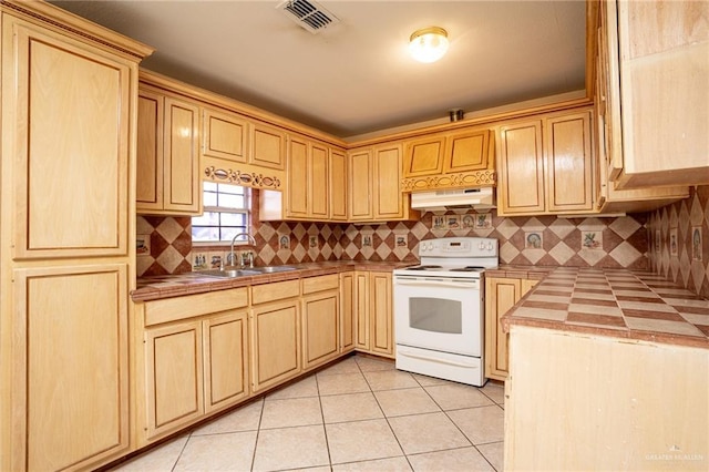 kitchen featuring sink, decorative backsplash, tile counters, light tile patterned floors, and electric stove